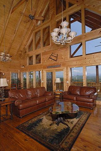 Living room area with a fireplace overlooking a Smoky Mountain View. Deluxe Leather furniture is in the living room area.